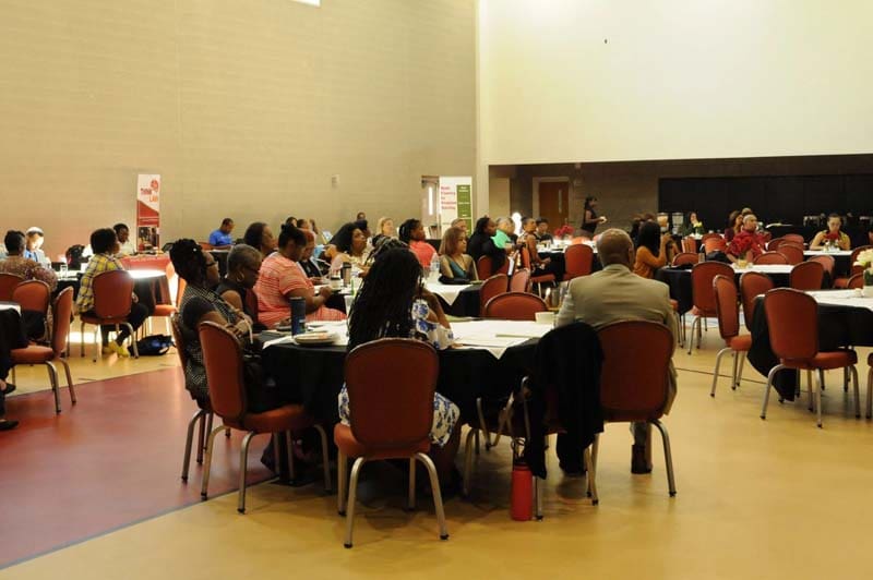 People gathered in a large room participating in a discussion or meeting.