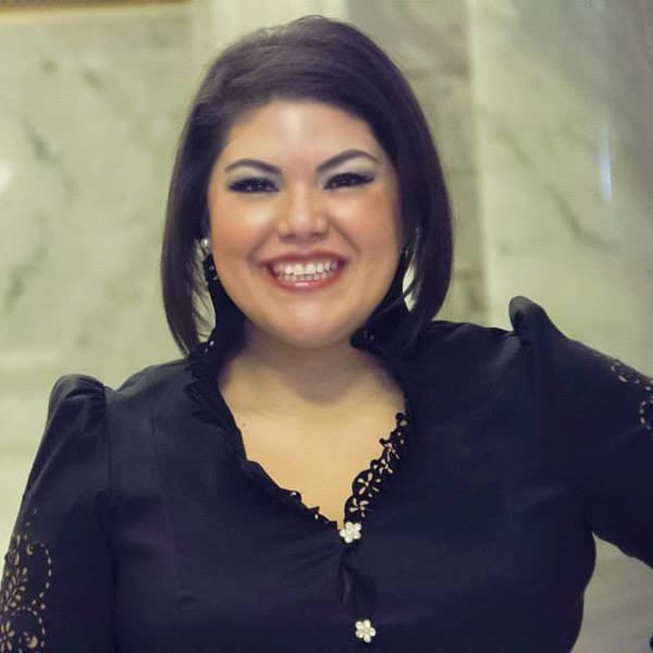 Smiling person in a black blouse.