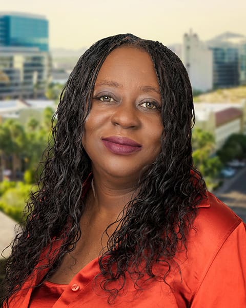 Woman smiling with cityscape in background.
