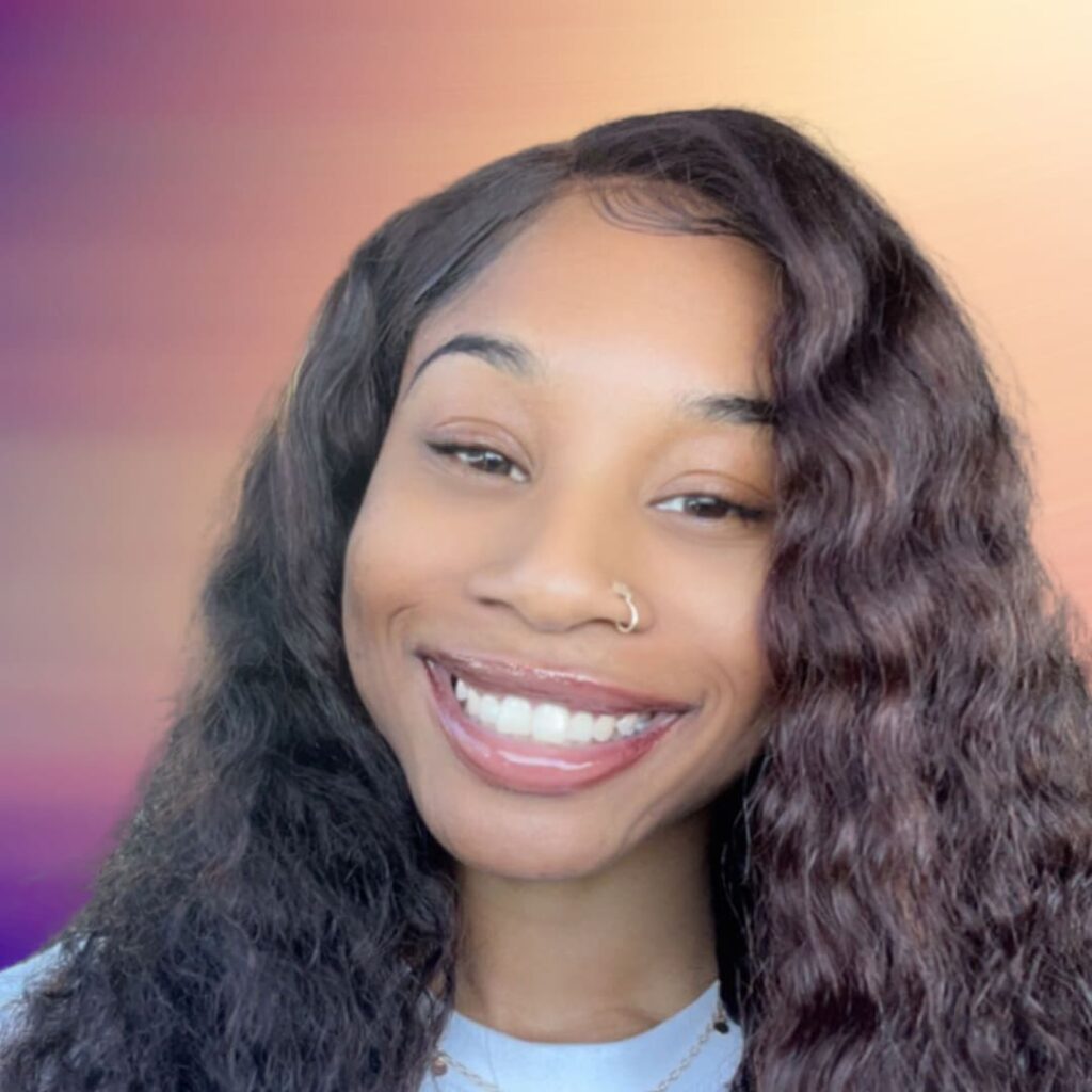 Smiling person with wavy hair, colorful background.