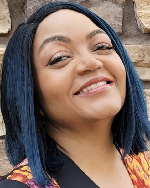 Smiling woman with blue and black hair.