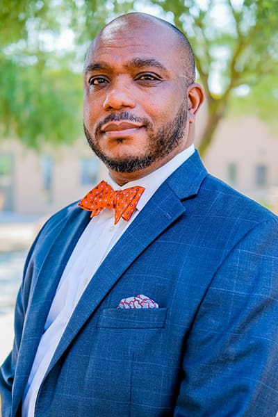 Man in suit with orange bow tie.