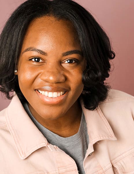 Smiling person in a pink jacket.