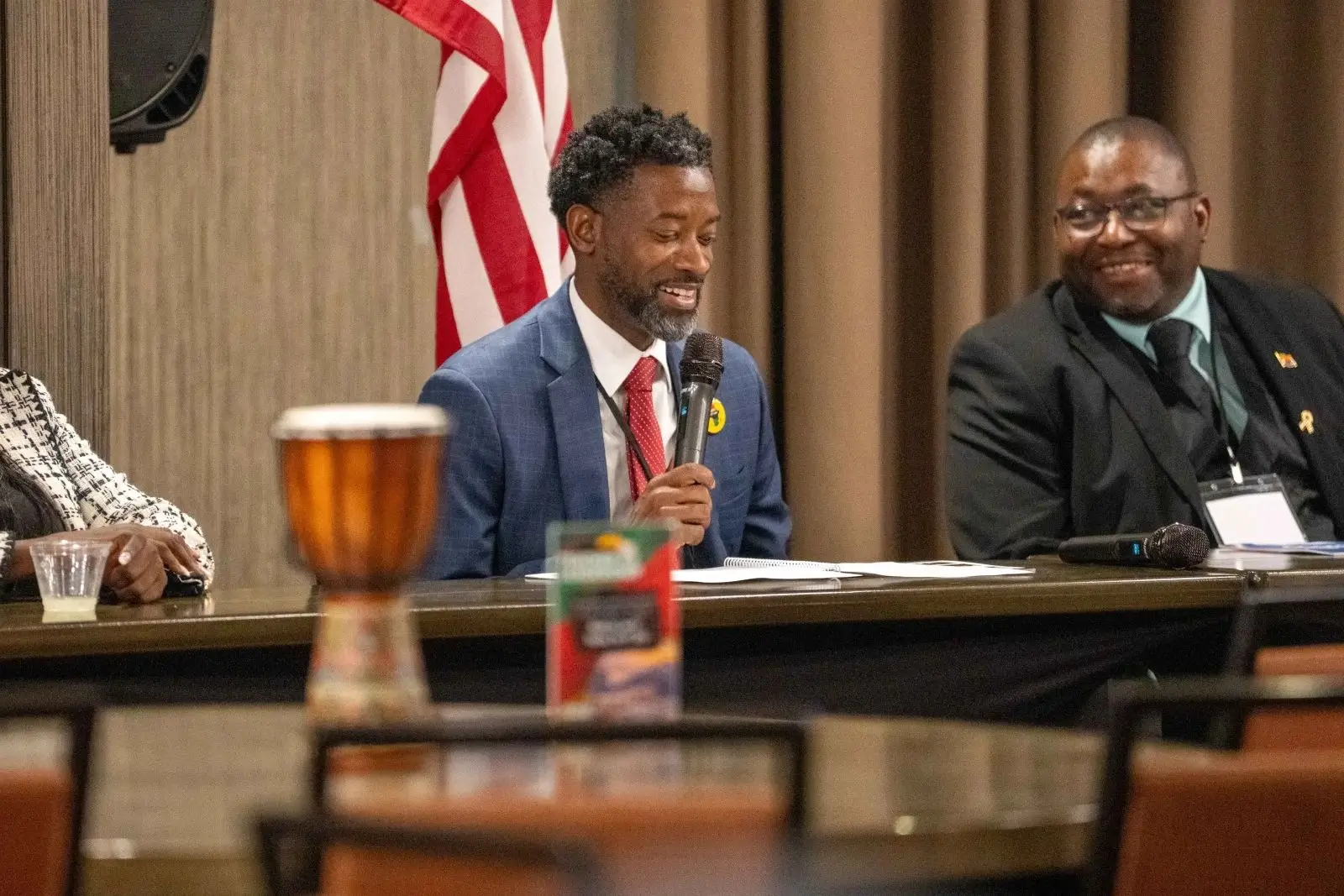 Panel discussion with smiling speakers and microphone.